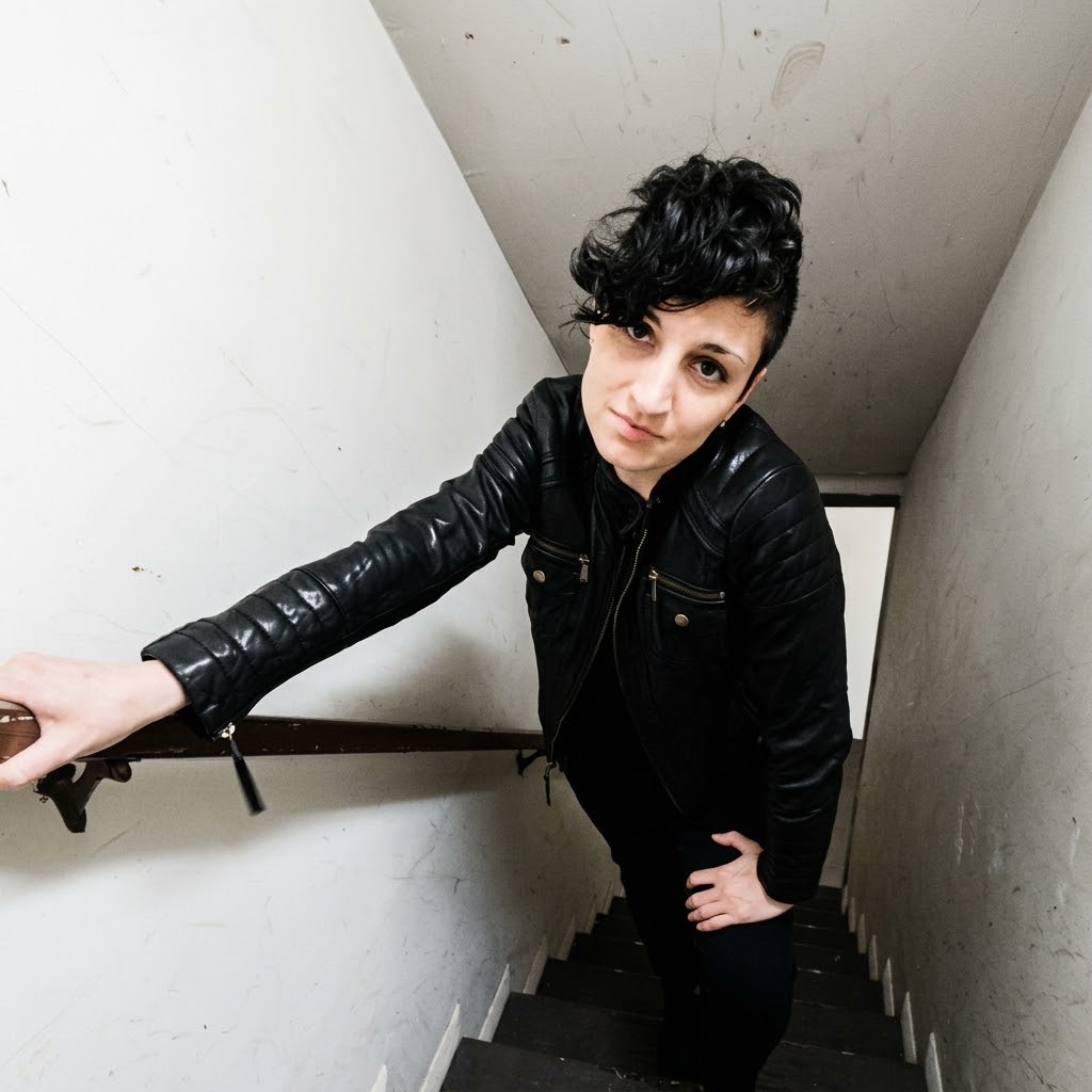 DJ Lenka Paris in a black leather jacket on a stairway