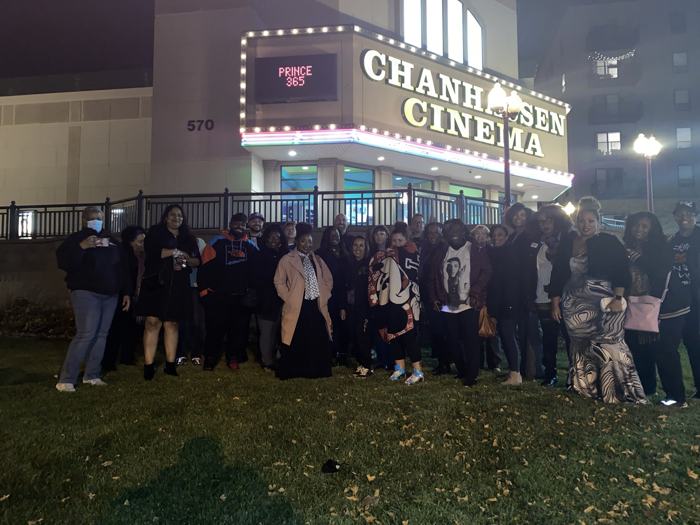 The Prince 365 group at night outside Chanhassen Cinema, marquee reading PRINCE 365