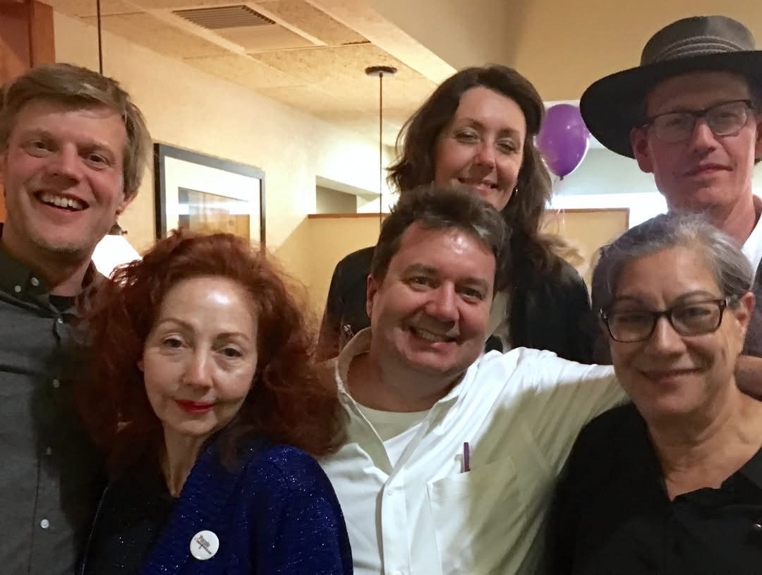 Six smiling faces with a purple balloon behind