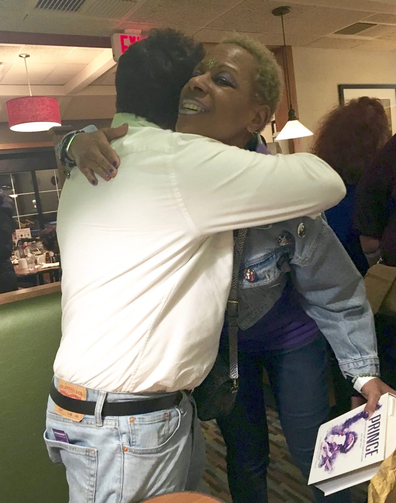 A hug with the denim jacket covered in pins